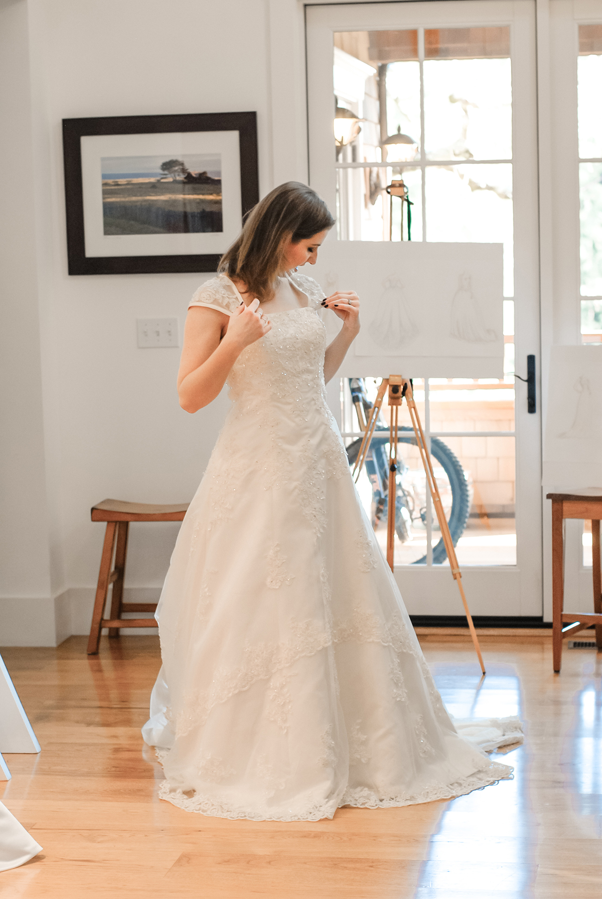 Devon examines the sleeves of a white lace A-line wedding dress
